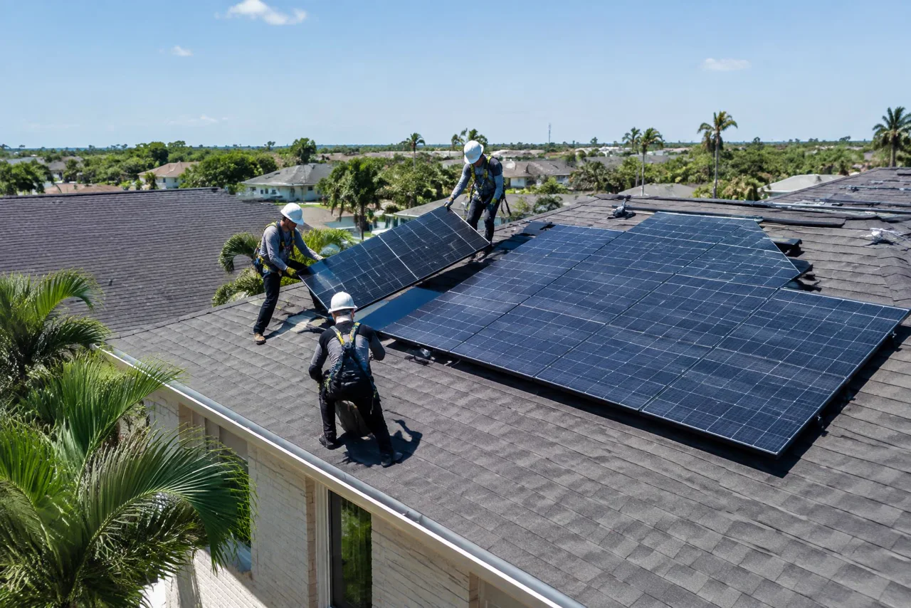 Illustrative crew detaching solar panels before roof work